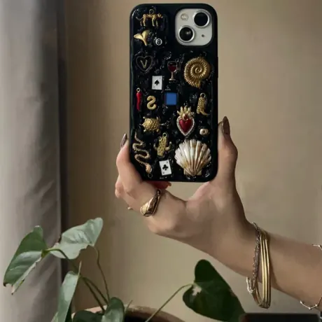 Funda negra ASTÉRIA con concha, mano y charms dorados